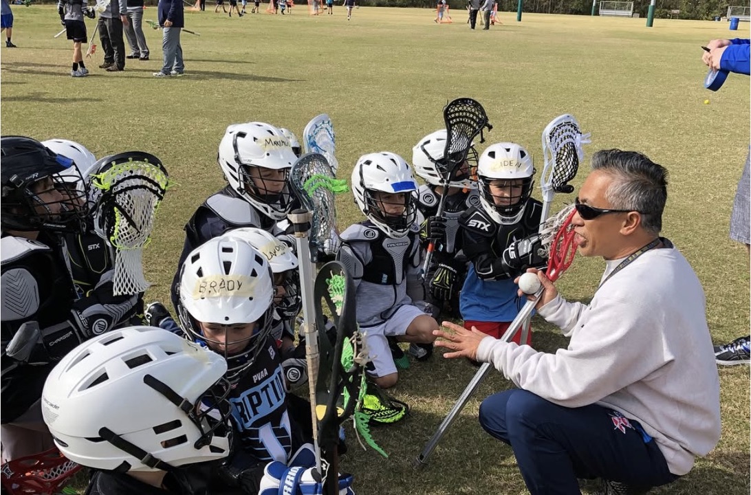 Boys Riptide players gathered around their coach during a sideline huddle