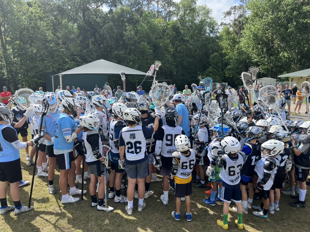 Ponte Vedra lacrosse players raising their sticks together after a game
